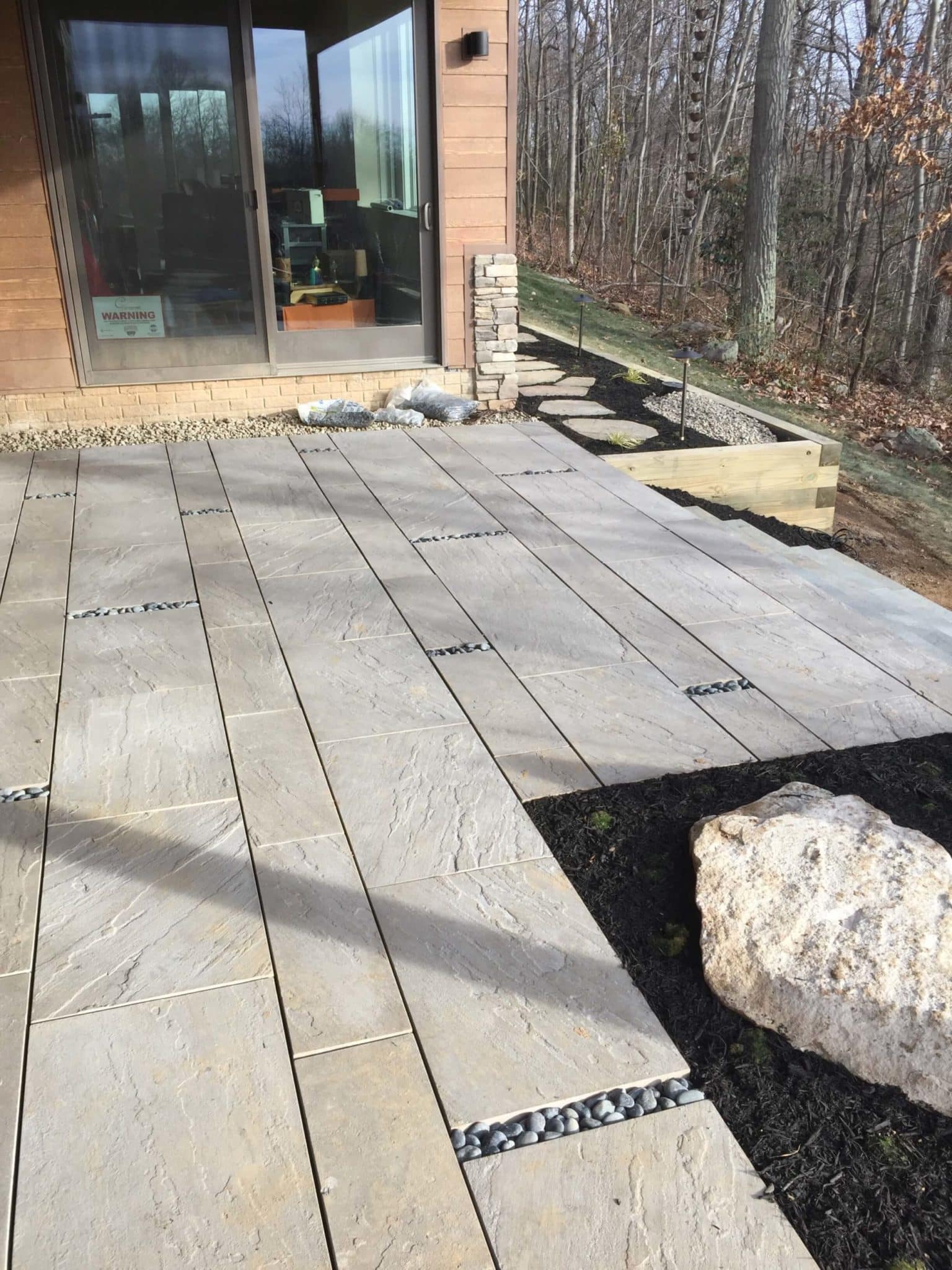581 Lower Level, Under-Deck Patio with Techo-Bloc Aberdeen Pavers and Mexican Beach Pebbles