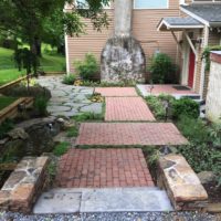 Unique Entry for Unique Home Features Mixed Materials and Fish Pond